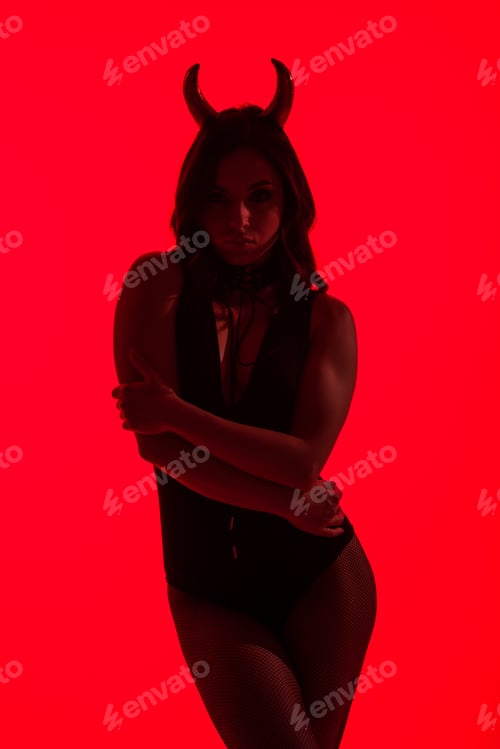Preview: silhouette of sexy woman in Devil costume, isolated on red