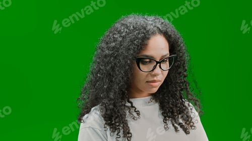 Preview: Young and beautiful African American woman in front of a green wall
