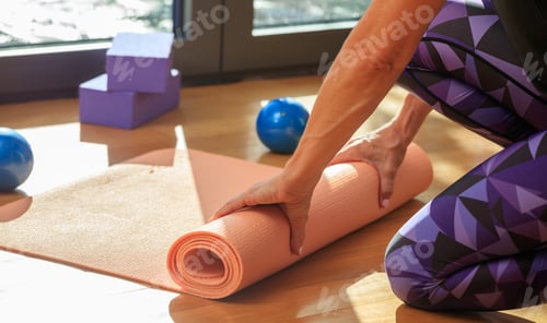 Preview: Woman Rolling Out Yoga Mat Inside Home