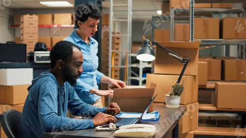 Preview: Young partners checking quality of merchandise packed in cardboard boxes