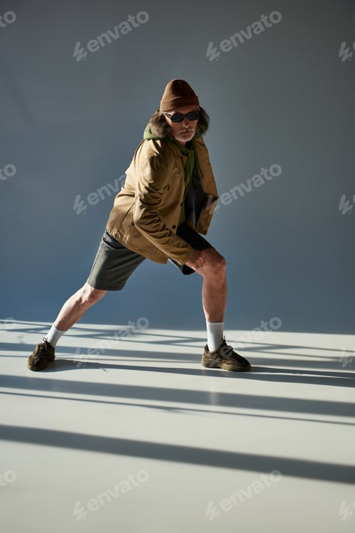 Preview: expressive and trendy personality, full length of senior man in dark sunglasses, beanie hat, jacket