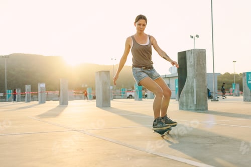 Preview: Athlete woman is skating on waveboard and have fun on the roof top in golden hour Outdoor activities
