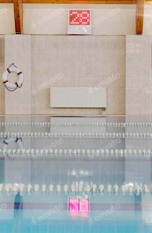 Preview: Indoor heated swimming pool, lifering and wall thermometer display, pink float in the water