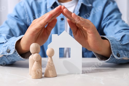Preview: White house, wooden figures and hands on light background