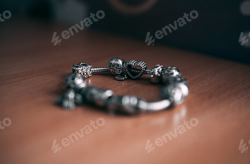Preview: Selective focus shot of a metal bracelet on a wooden surface