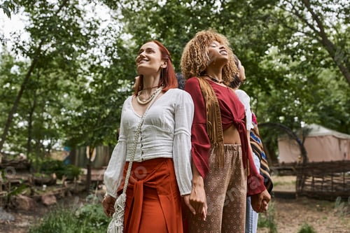 Preview: smiling redhead woman holding hands of multiethnic friends outdoors in retreat center