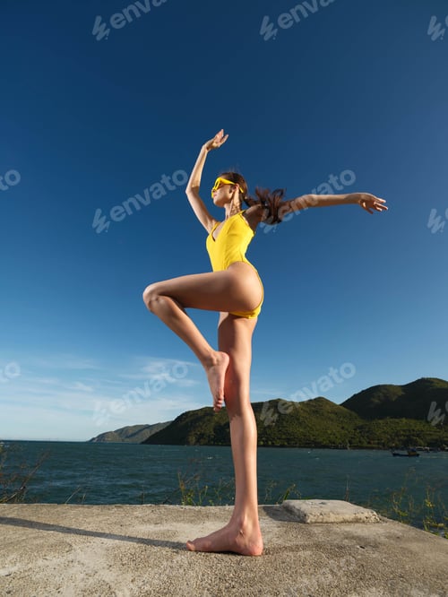 Preview: Yellow swimsuit, woman, handstand, concrete wall, water, blue sky a woman in a yellow swimsuit