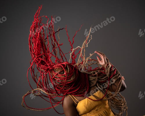 Preview: African American female wearing a bright yellow dress with her long red hair blowing in the wind