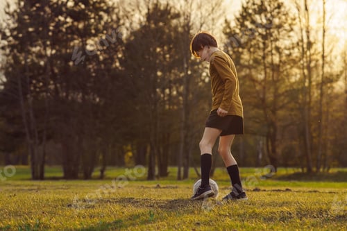 Preview: 11-13 - year - old teenager in sports uniform trains on field with soccer ball. Football practice.