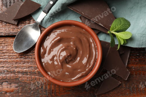Preview: Tasty pudding with mint and pieces of chocolate served on wooden table, flat lay