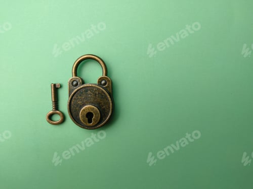 Preview: Bronze vintage padlock and a key on soft green paper background with copy space