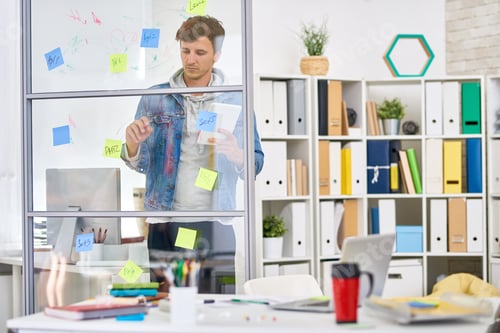 Man Planning Strategy Using Sticky Notes in Office