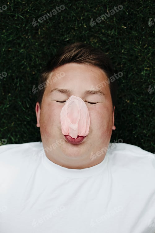 Preview: Portrait of teenage boy blowing bubble gum bubble