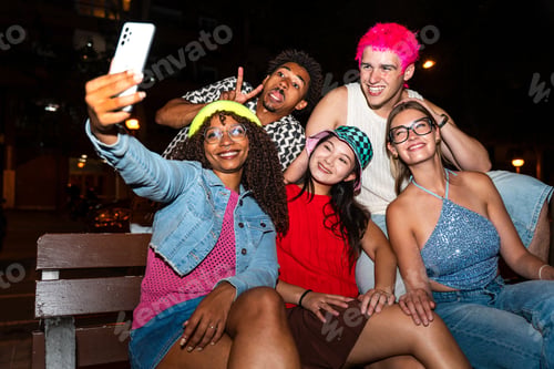 Preview: Multiethnic group of young friends having fun on the stretts in the night