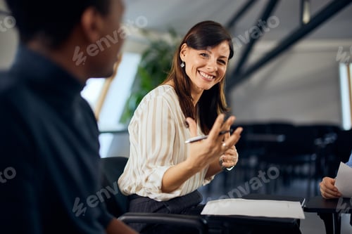 Preview: A smiling female therapist is talking to all the people during group psychotherapy.