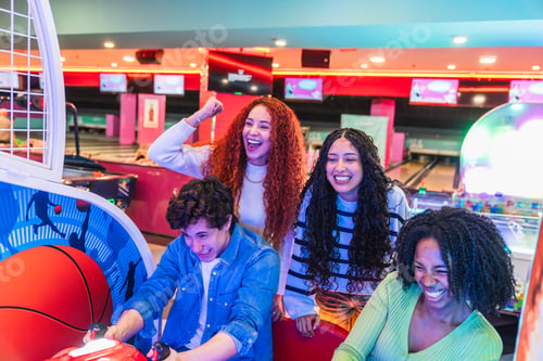 Preview: Friends playing arcade games in bowling alley having fun