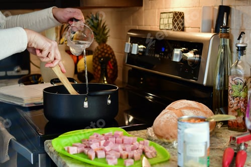 Preview: Cooking on the stove in the kitchen. Adding water to a pot of soup. Making supper at home.
