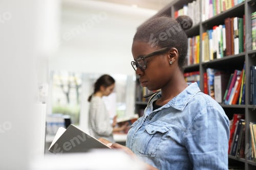 Preview: African woman with book in the library