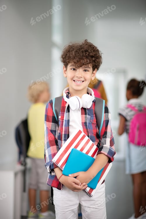 Preview: Dark-haired boy smiling while walking to classroom