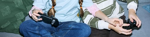 Preview: Children Playing Video Game Together Using Game Controllers Indoors
