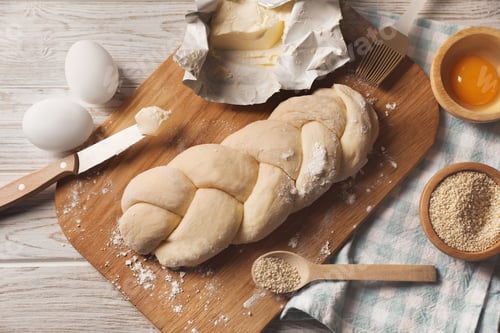 Preview: Raw braided bread and ingredients on white wooden table, flat lay. Traditional Shabbat challah