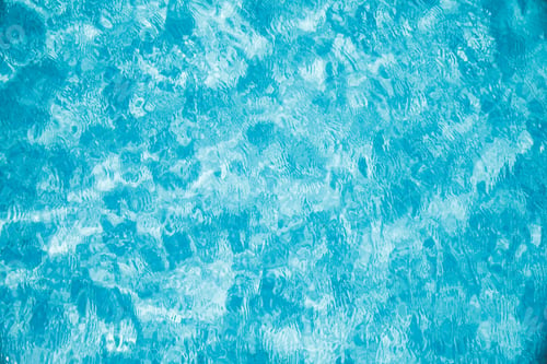 Preview: Water background, surface of the pool in ripples and sun glare. Nature background, vacation concept