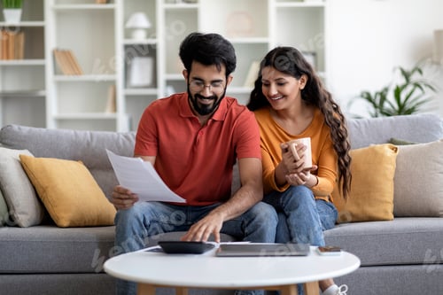 Preview: Indian Married Couple Planning Budget Together, Reading Papers And Calculating Spends