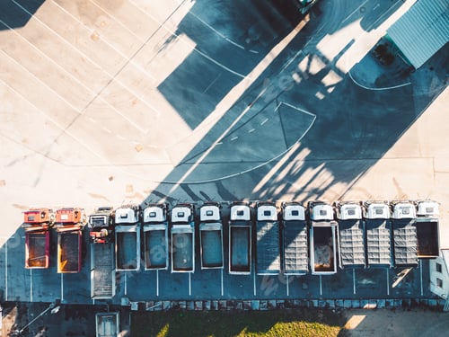 Preview: Top down view of construction trucks parked in a line at the road repair base
