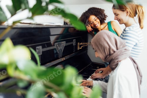 Preview: Cute smiling female teenagers play duets on the old piano.