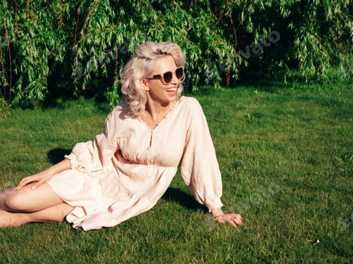 Preview: Young beautiful smiling blond woman posing outdoors