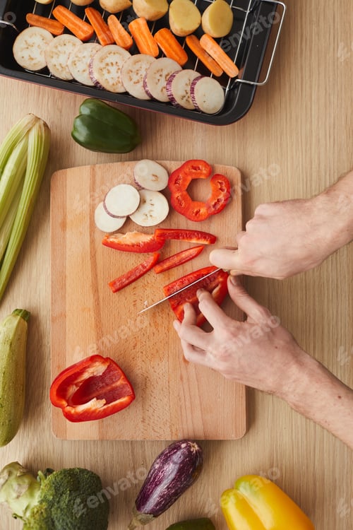 Preview: Man cutting vegetables on cutting board