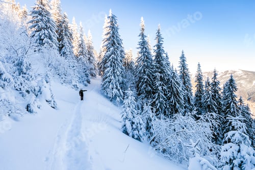 Preview: A male mountaineer walking uphill on a glacier.