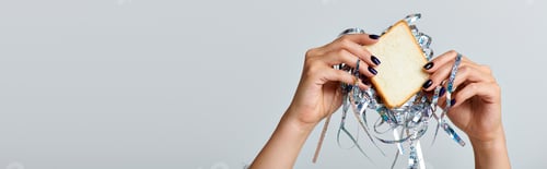 Preview: partial view of woman holding sandwich with tinsel on grey backdrop, Happy New Year concept, banner