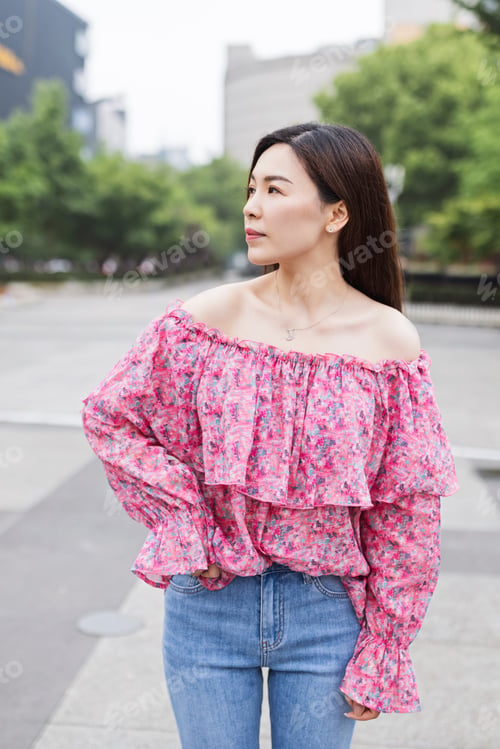 Preview: Candid portrait of attractive trendy asian woman which walks in urban park in China