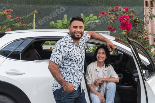 Preview: Happy young couple smiling with car ready for road trip