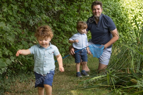 Preview: Father and children with fishing net in park