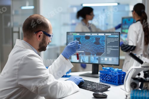 Preview: Biologist researcher holding blood test tube in hands analyzing virus expertise