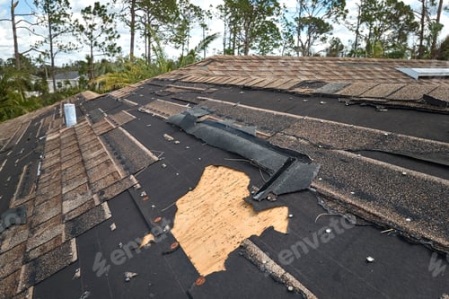 Preview: Damaged house roof with missing shingles after hurricane Ian in Florida.