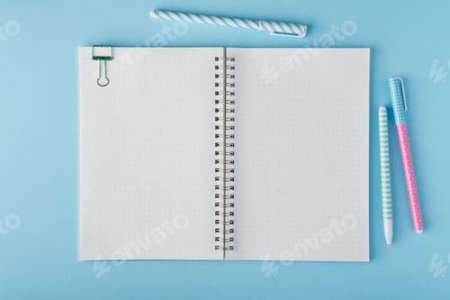 Preview: Blank notepad page in bullet journal on bright blue office desktop