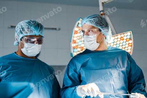 Preview: nurse and surgeon in uniforms and medical masks doing operation