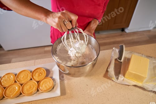 Preview: Faceless woman mixing cream in bowl