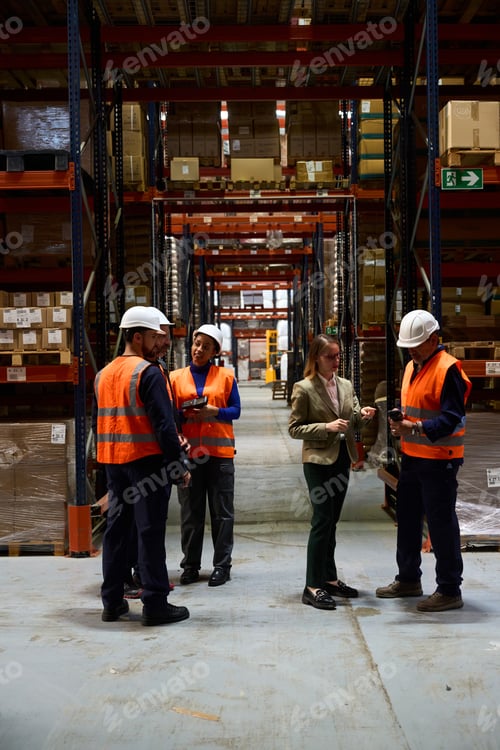 Preview: Logistics team meeting inside a busy warehouse discussing operations