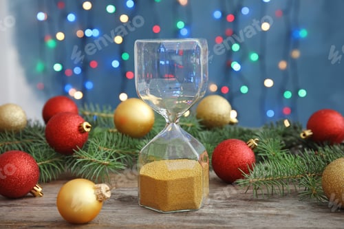 Preview: Hourglass and festive decor on table. Christmas countdown