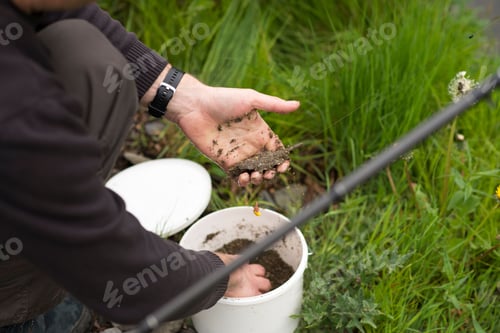 Preview: Closeup of the man grabbing soil from the bucket.