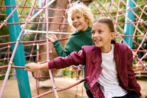 Preview: Joyful children climbing and playing together in an autumn park, surrounded by colorful leaves