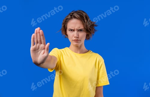 Preview: Serious woman demonstrates stop forbidden gesture, assertive body language