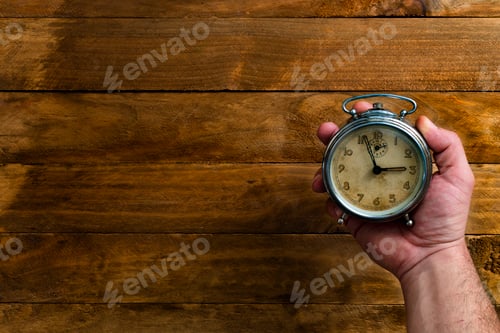 Preview: Hand holding an antique clock.