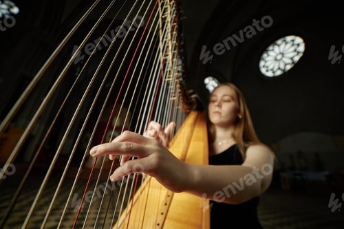 Preview: Hand of Female Harpist Playing Music Strumming Strings during Performance in Church