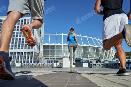 Preview: Young girl and men in sportive clothes running to stadium