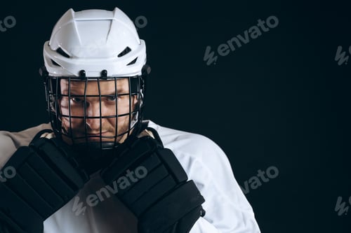 Preview: Portrait of ice-hockey player with hockey stick and protective gloves
